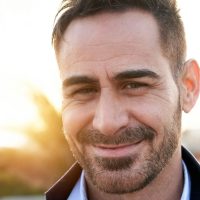 Portrait of a handsome mature man looking at the camera outdoors. Spanish person with nice smile